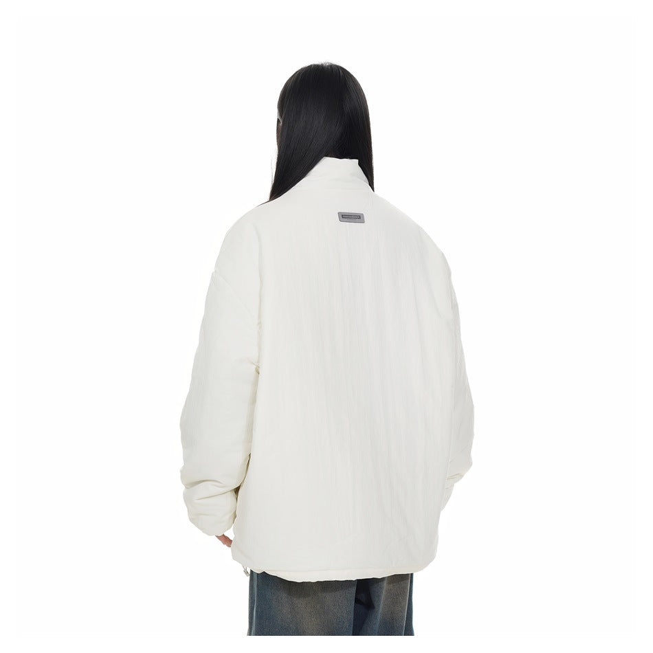 Rear view of a model wearing an oversized ivory padded jacket with a high collar and dropped shoulders.
