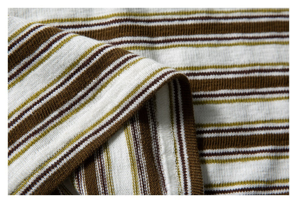 Close-up of the striped shirt fabric folded back to show its stitched edge and inner seam.