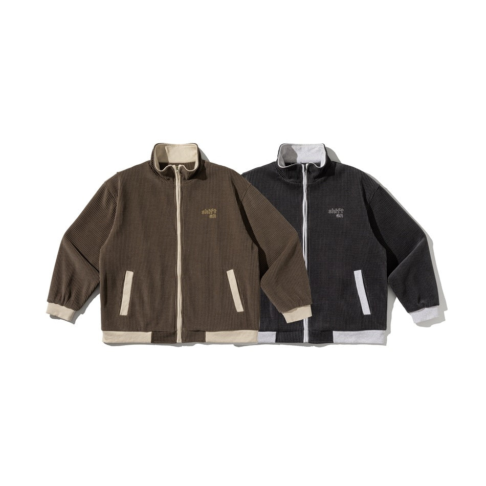 Two ribbed zip-up jackets shown side by side: brown with cream trim and charcoal with light gray trim.
