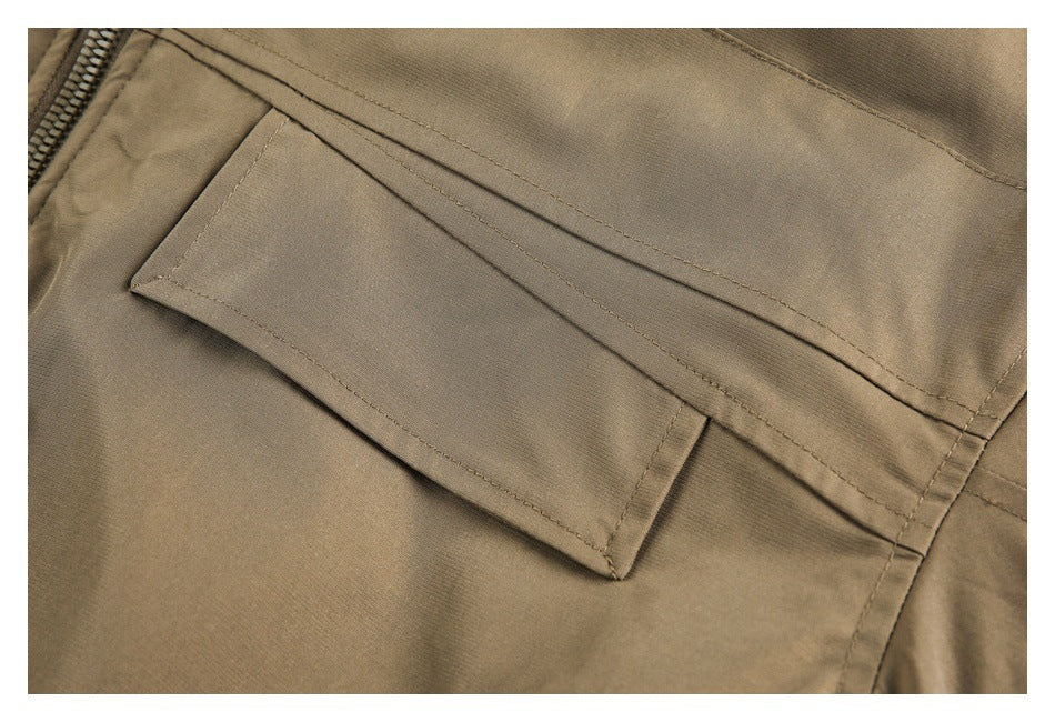 Close-up of a stitched flap pocket on tan trousers.