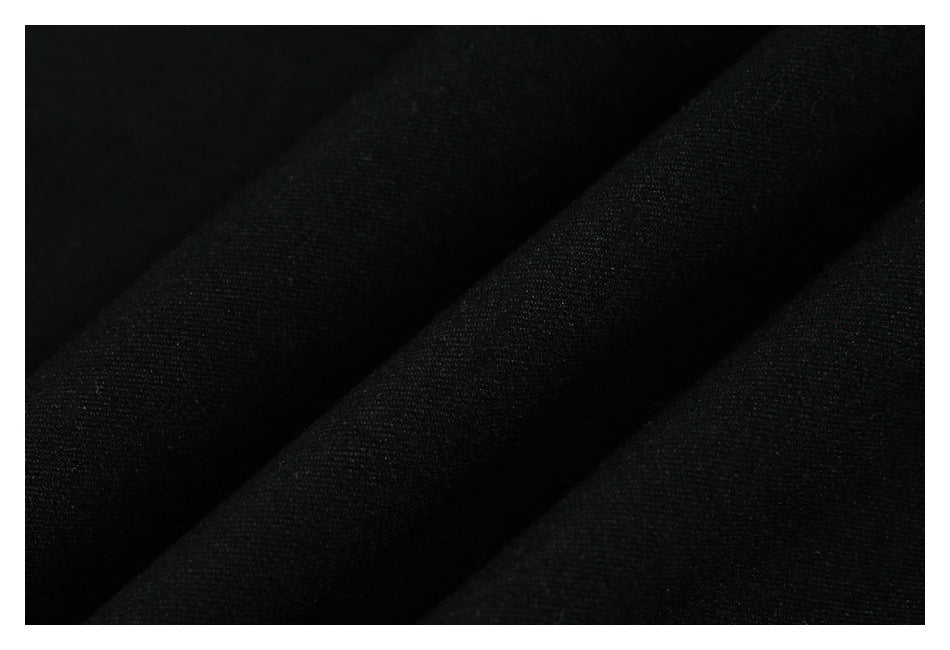 Close-up of black fabric with a subtle woven texture and soft diagonal folds.