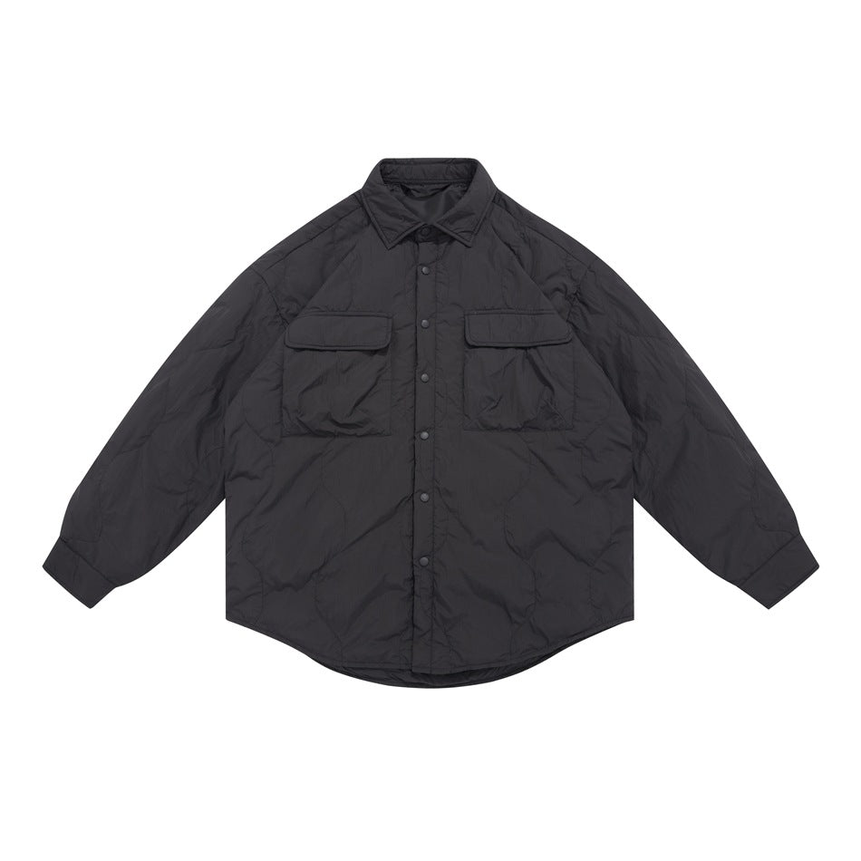 Front view of a black quilted shirt jacket with a pointed collar, snap-button placket, two flap chest pockets, and long