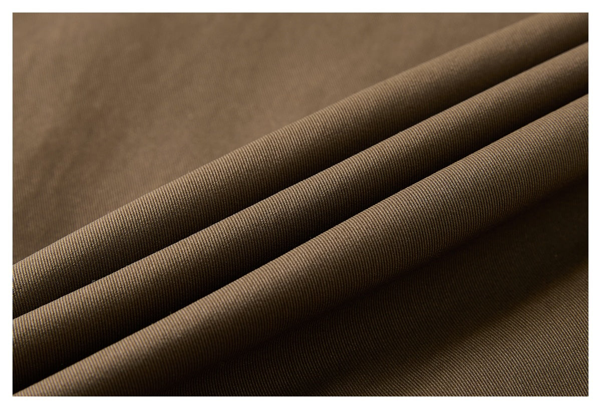 Macro view of brown fabric folded into ridges, showing its fine diagonal weave.