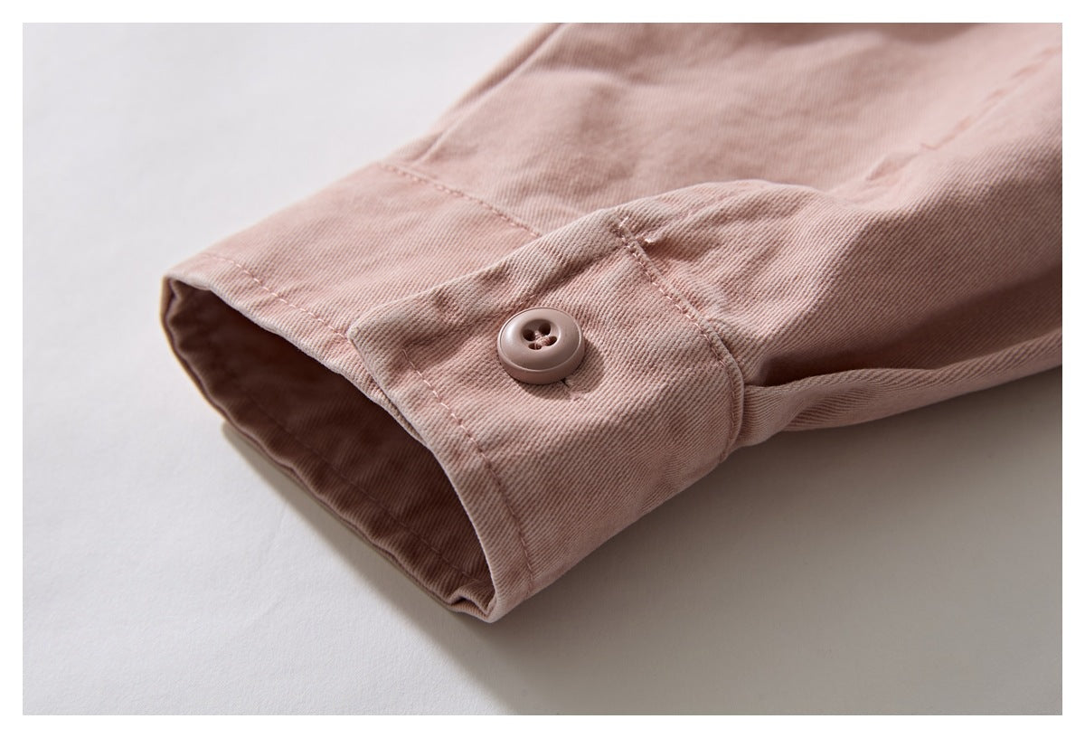 Close-up of the dusty rose shirt cuff with a matching four-hole button and visible stitching.