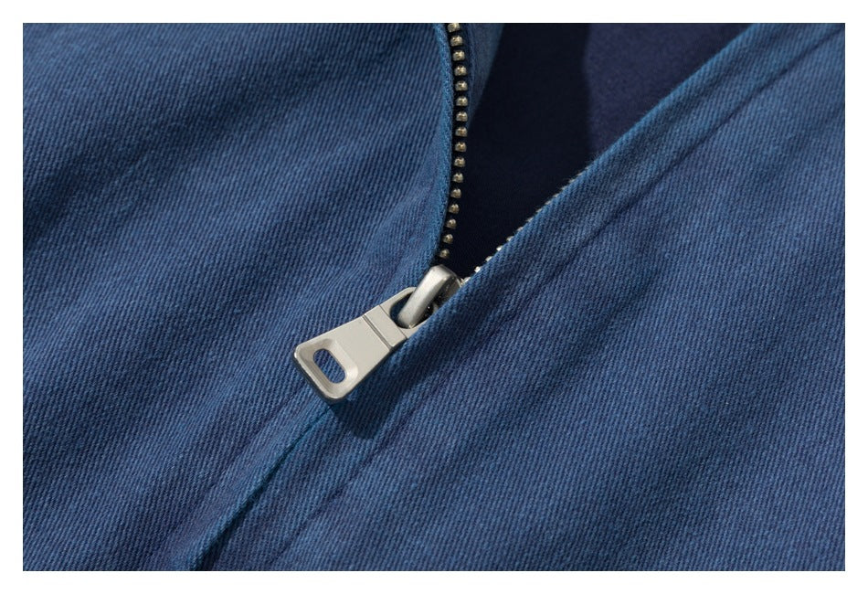 Close-up of a metal zipper on dark blue fabric.