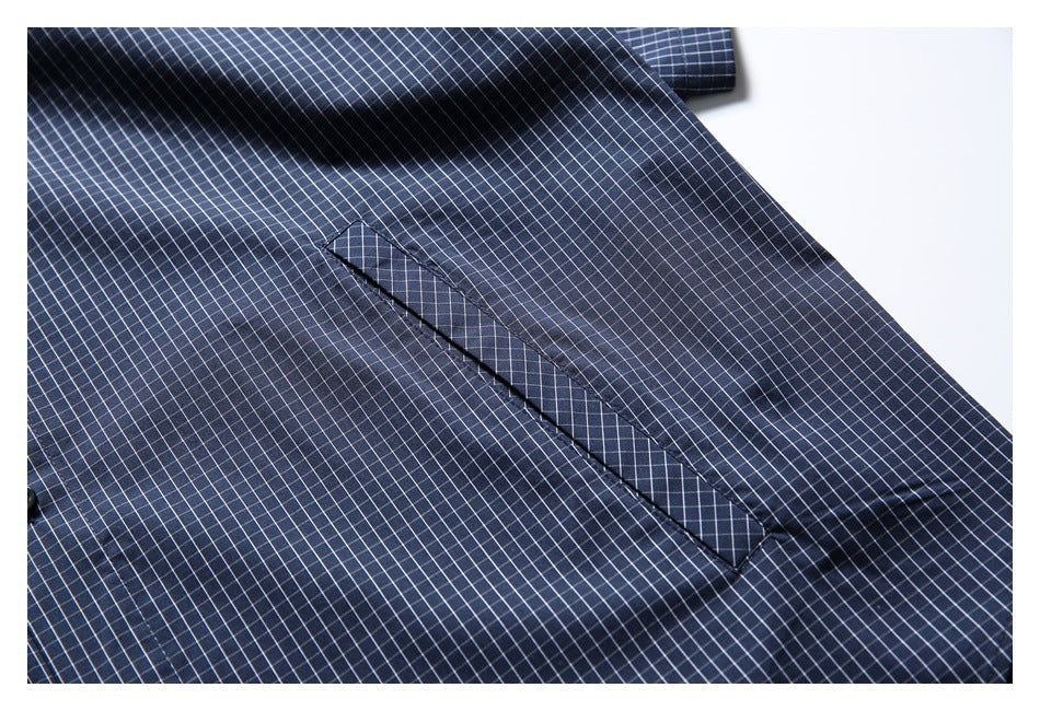 Close-up of a navy check shirt pocket opening and fine white grid pattern.