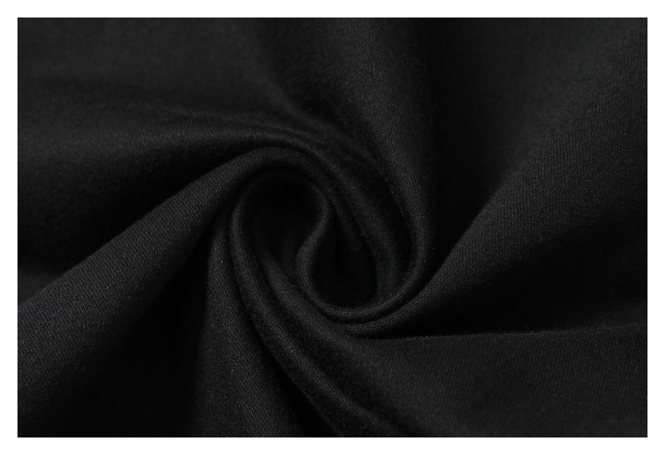Close-up of black fabric gathered into a spiral, showing its fine surface texture.