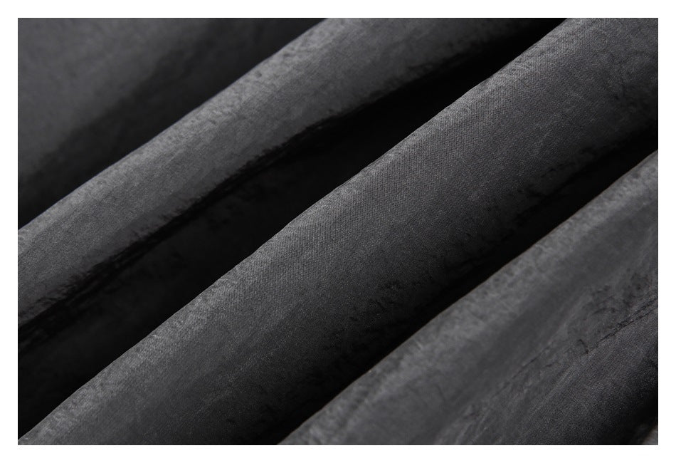Macro view of the lightly crinkled, dark charcoal garment surface and folds.