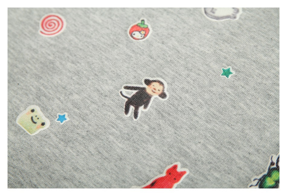 Close-up of playful small colorful character and star motifs printed on heather-gray fabric.