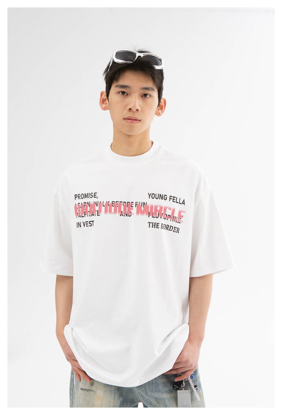 Model wearing an oversized white T-shirt with layered red and black text across the chest.