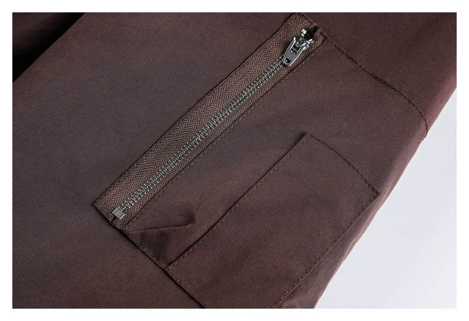 Close-up of a dark brown jacket pocket with a diagonal zipper and stitched pocket panel.