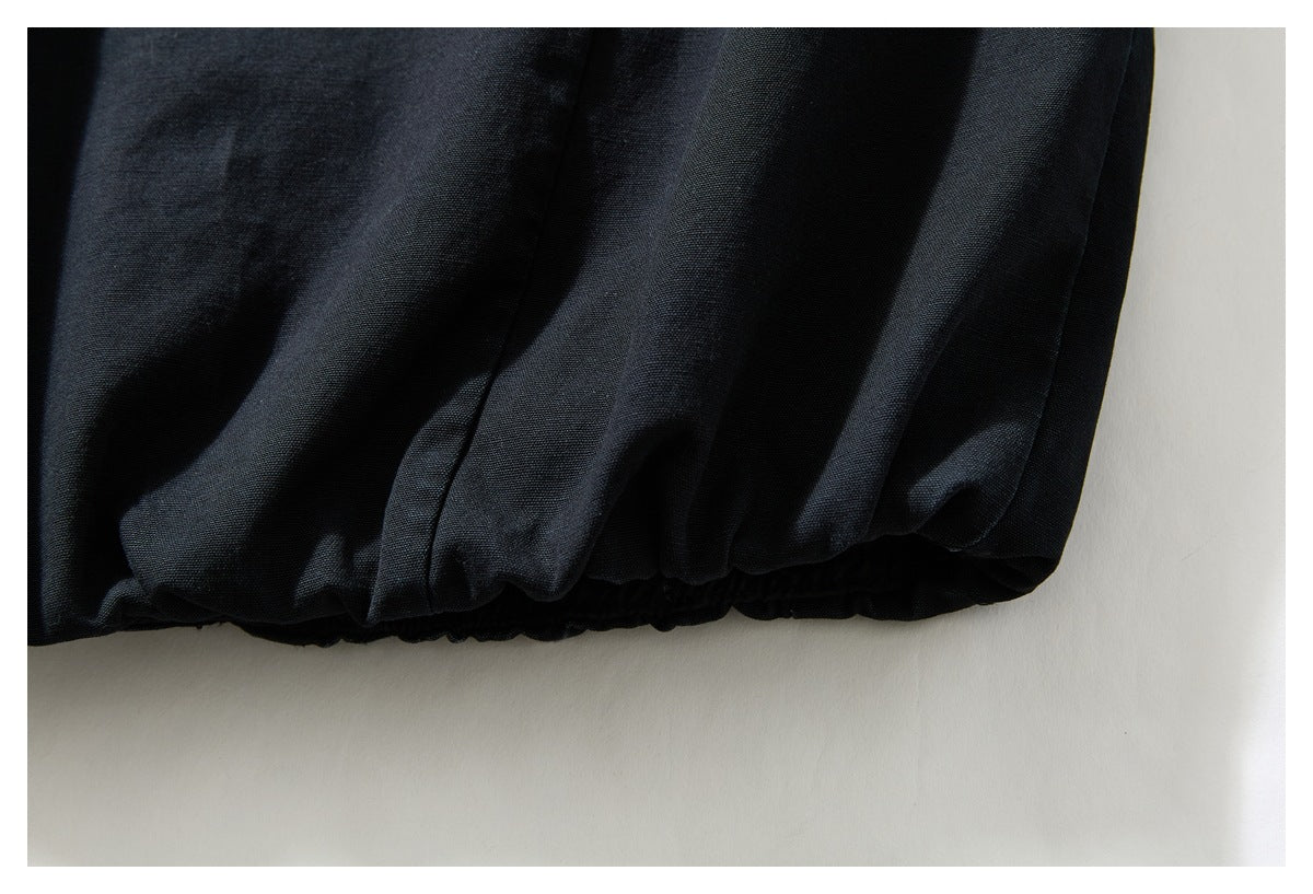 Close-up of a black garment's elasticized edge and gathered stitching.