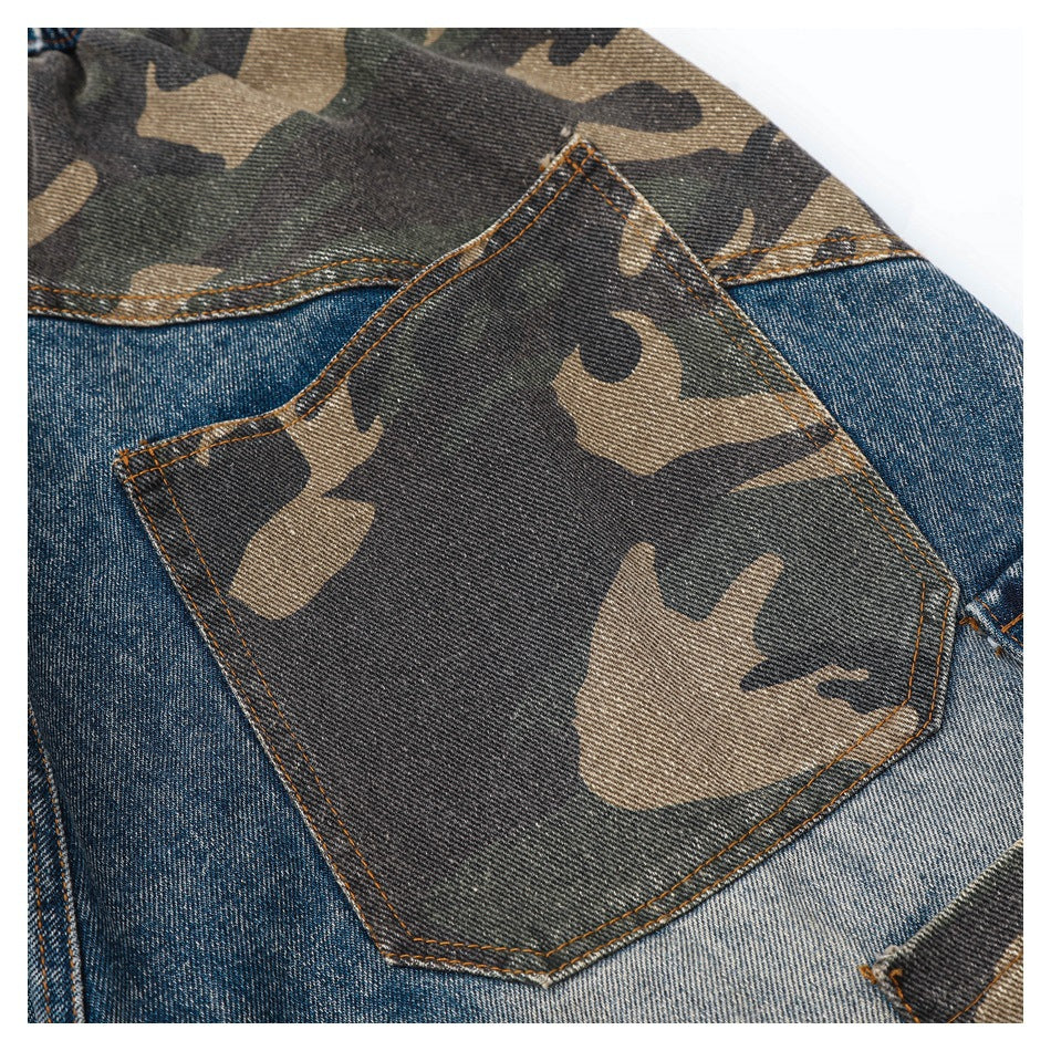 Close-up of a camouflage-print patch pocket sewn onto blue denim.
