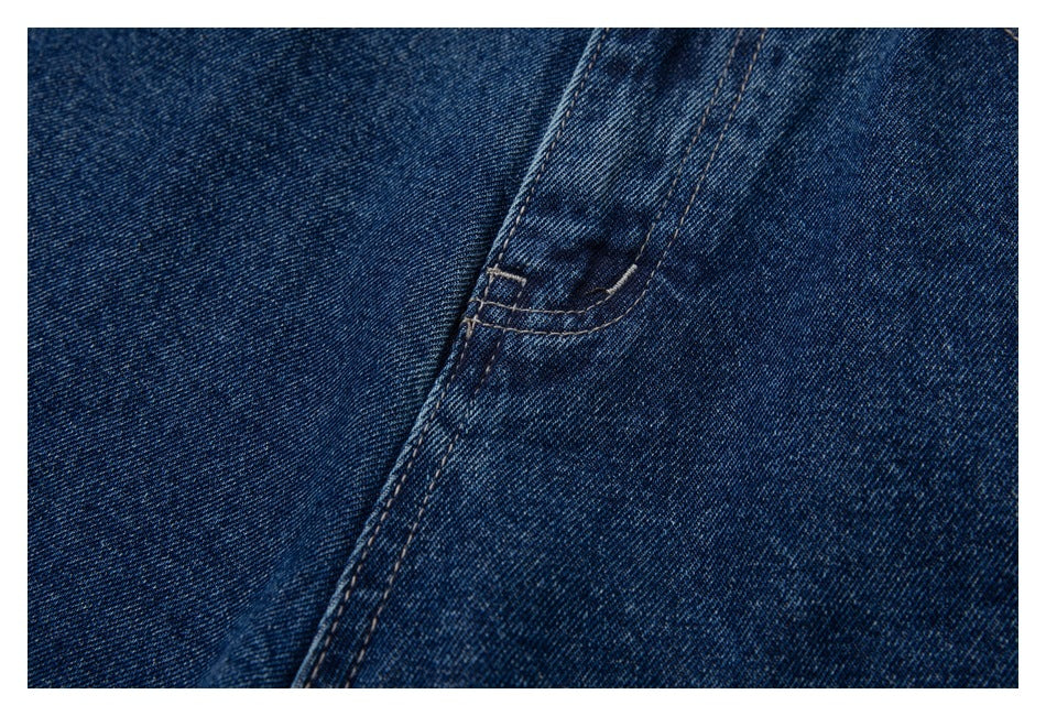 Close-up of dark blue denim with diagonal seam stitching.