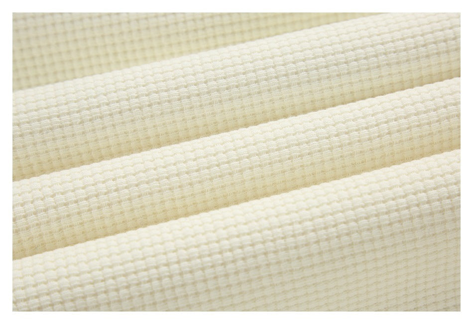 Close-up showing the raised, grid-like texture of off-white fabric.