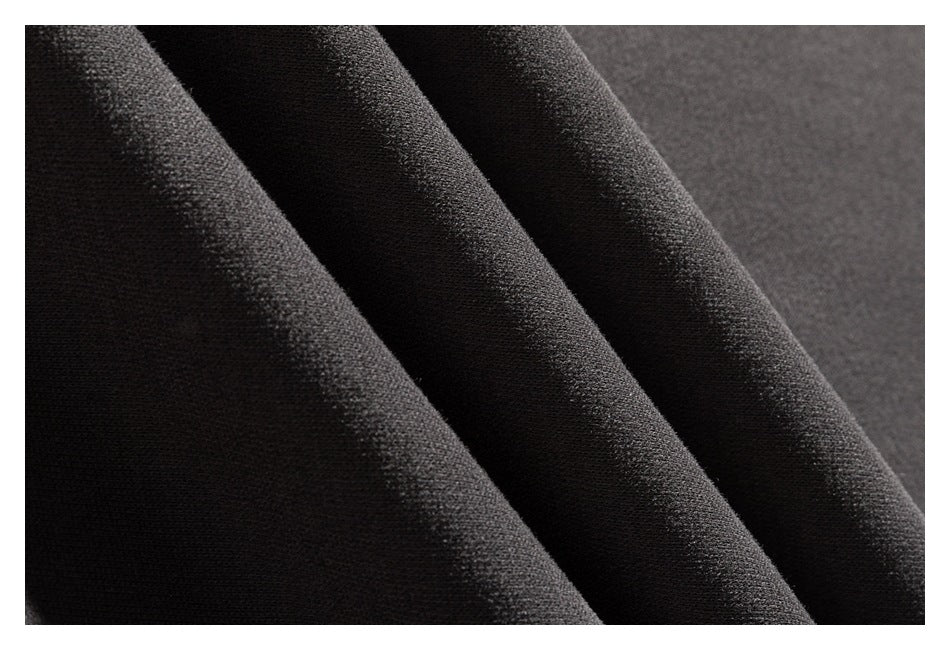 Macro view of the charcoal sweatshirt fabric draped in folds.
