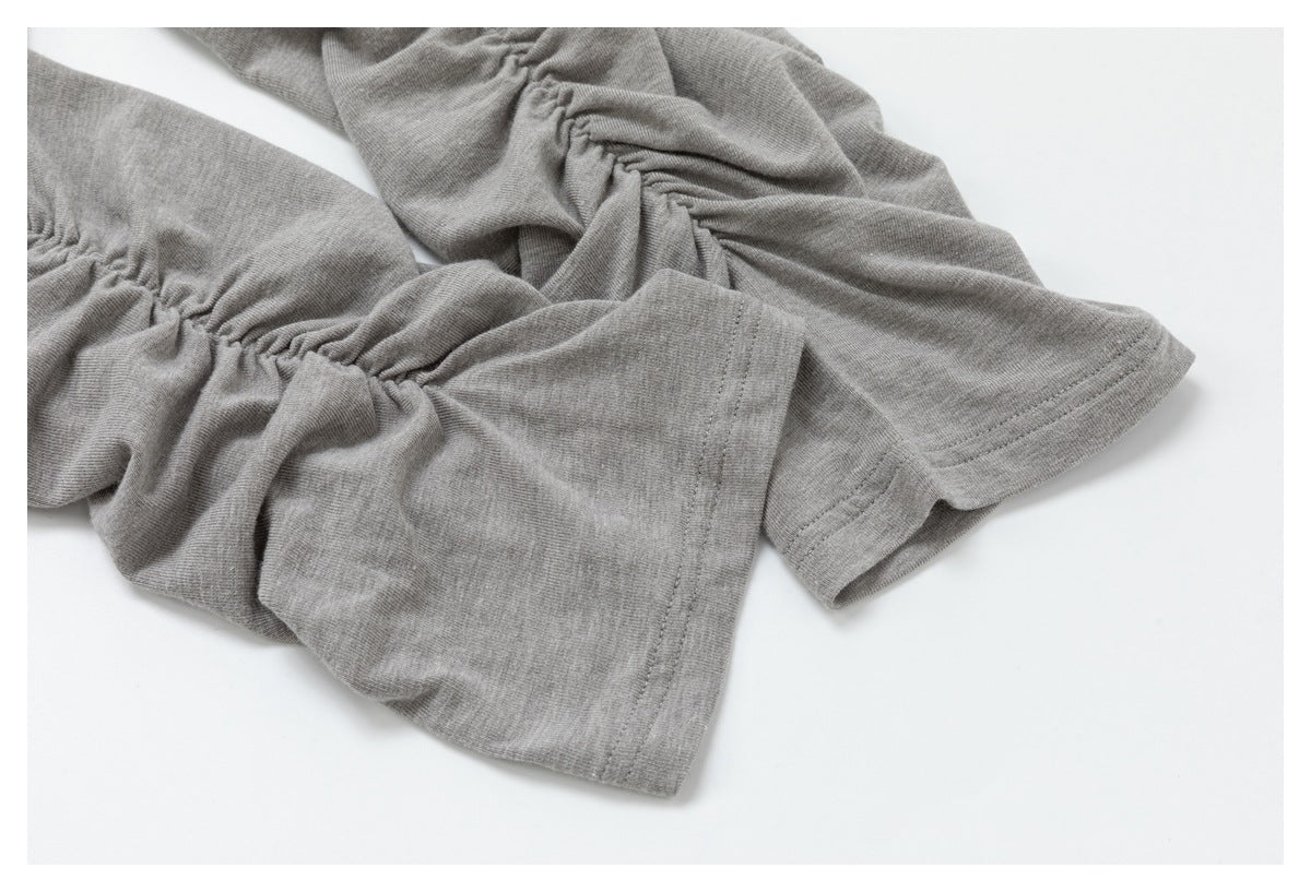 Close-up of a gray garment with gathered ruching and stitched sleeve cuffs.