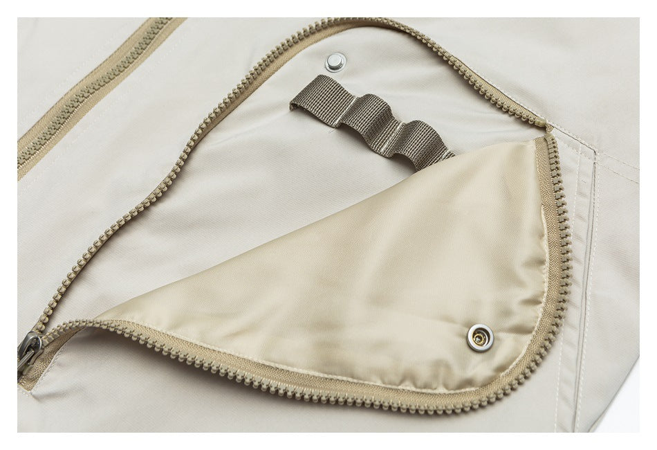 Open zippered pocket on a light beige garment reveals a pale lining and short elastic loops.
