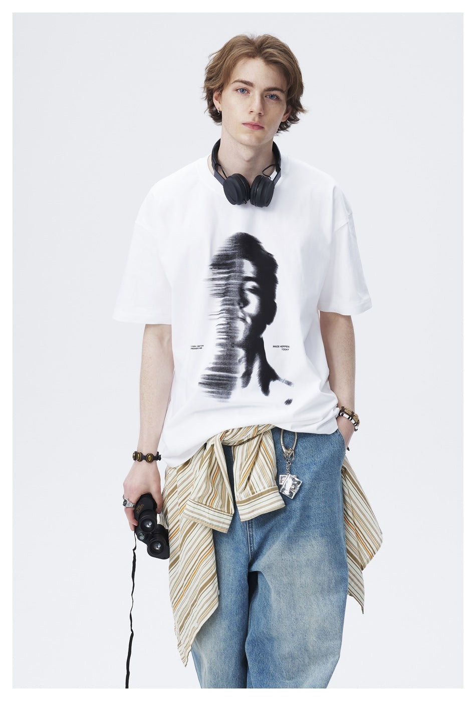 Front view of a model wearing a white short-sleeve T-shirt with a large black distorted portrait graphic.