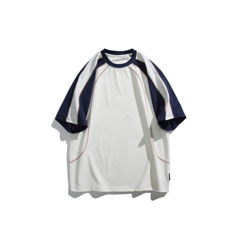 Front view of a cream oversized raglan tee with navy and pale sleeve panels and curved contrast stitching, shown flat against