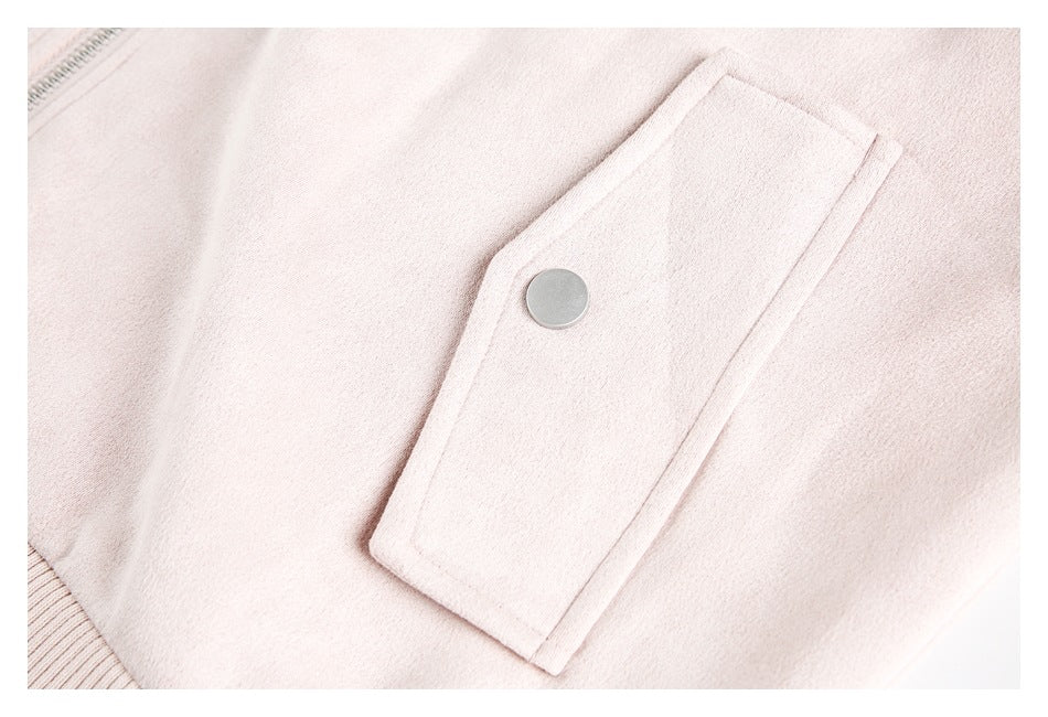 Close-up of a pale pink jacket pocket with a metal snap closure.