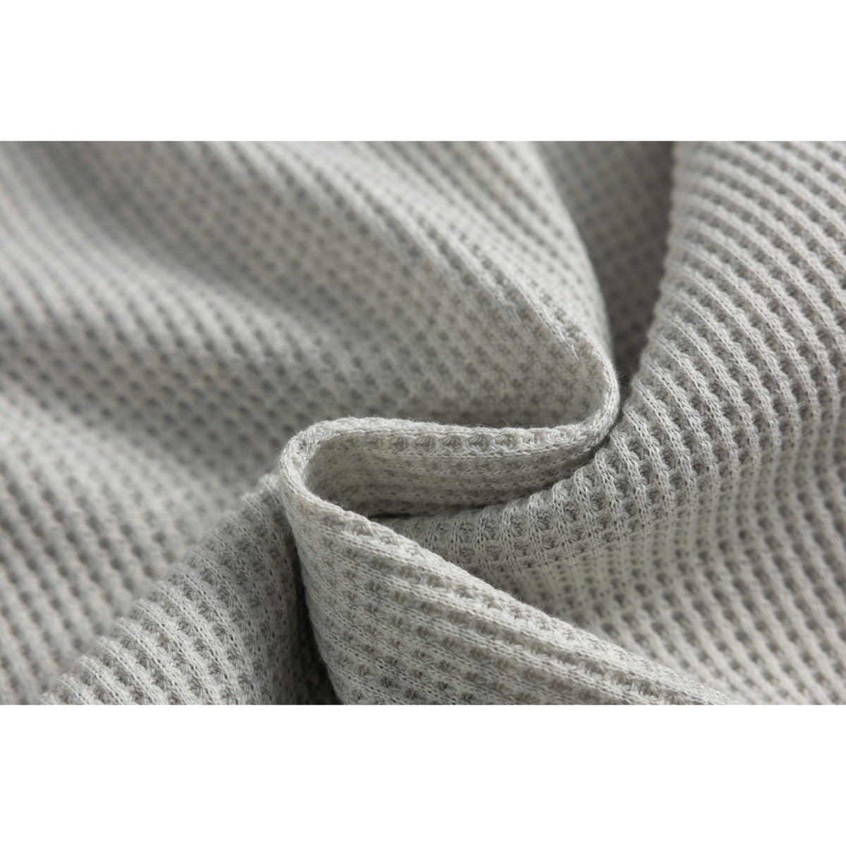 Close-up showing the texture and folded edge of light gray fabric.