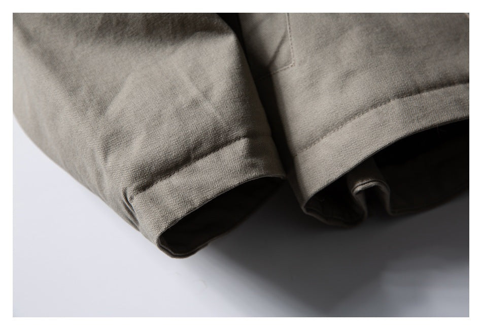 Close-up of the taupe-gray jacket's stitched sleeve cuffs and hem.