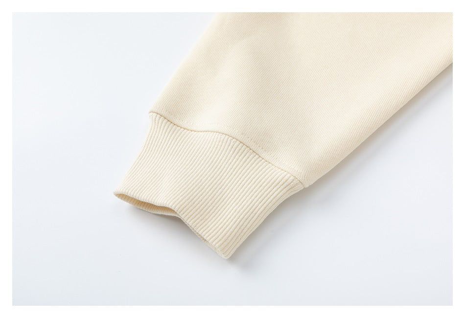 Close-up of a cream sweatshirt sleeve ending in a wide ribbed cuff.