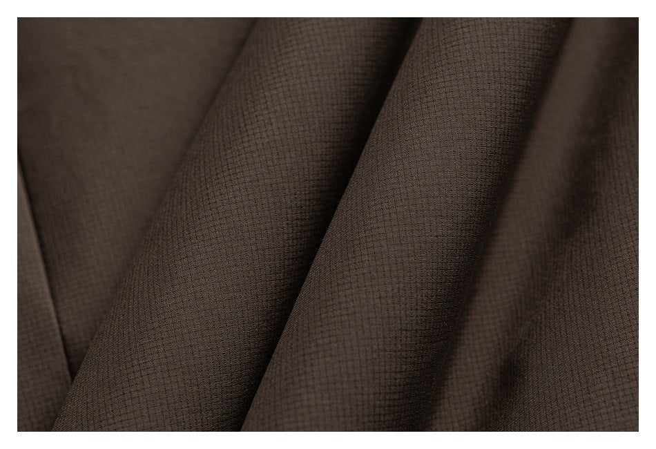 Macro view of dark brown fabric with a fine, subtly textured weave.