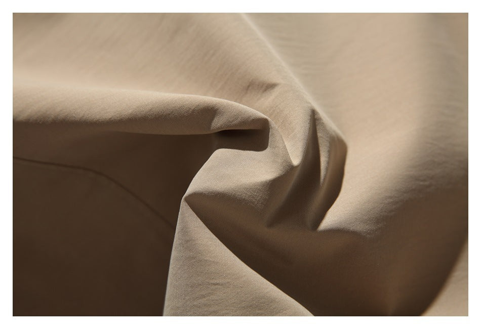 Close-up of softly folded beige coat fabric.