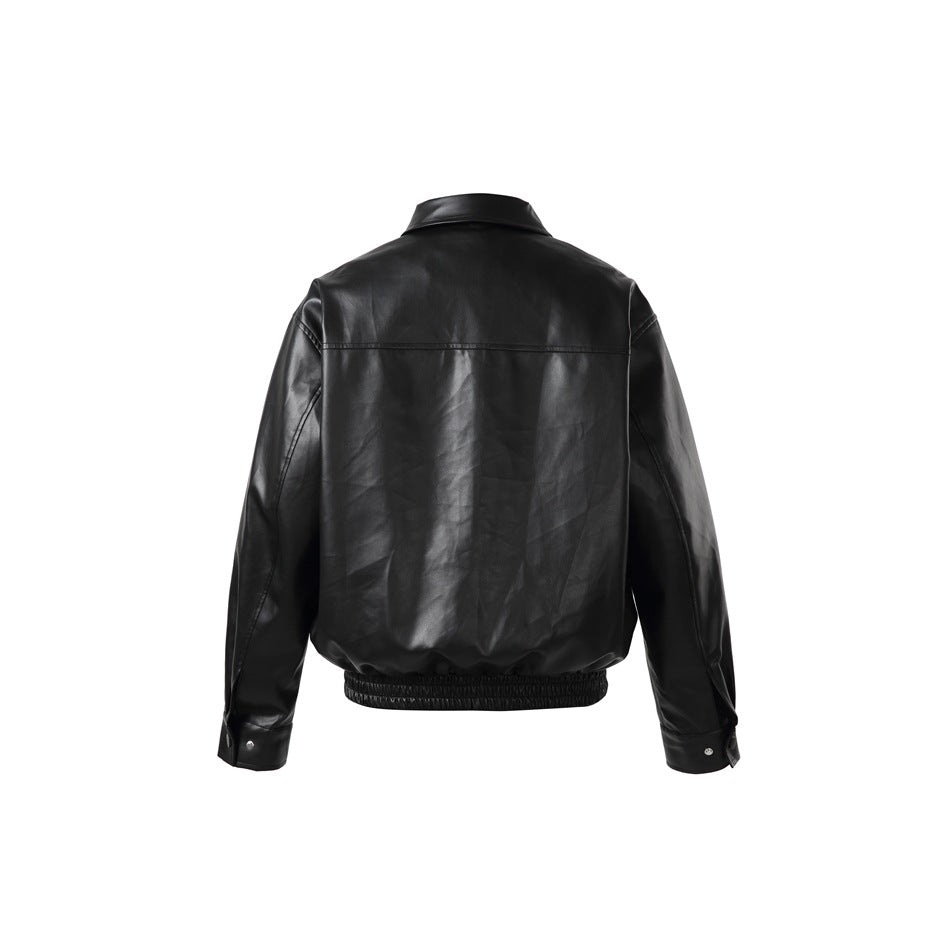 Back view of a black collared jacket with a horizontal yoke seam, long sleeves, snap cuffs, and an elastic hem.