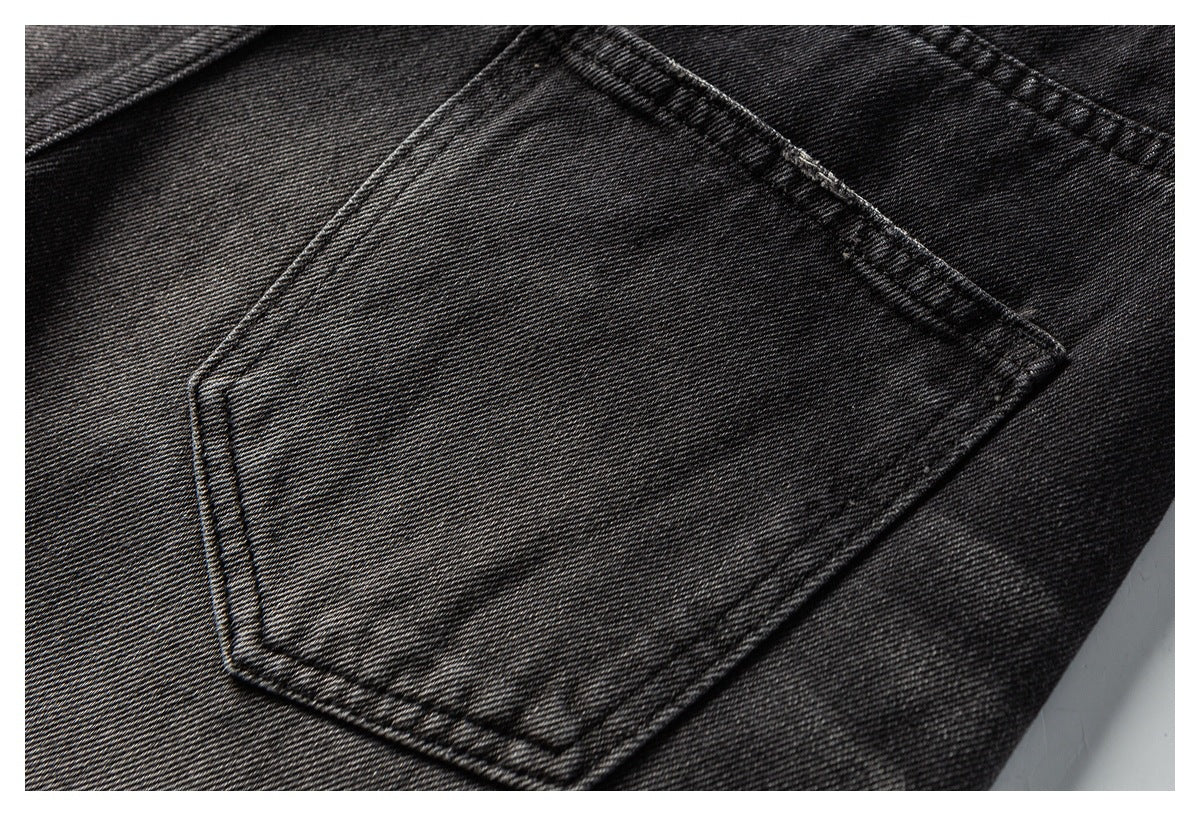 Close-up of a back pocket and stitching on black denim jeans.