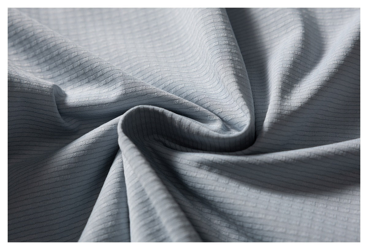 Close-up of light gray fabric gathered to show its fine horizontal ribbed texture.