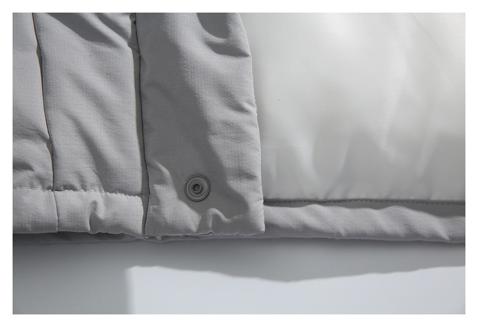 Close-up of a light gray jacket cuff with a snap button and stitched hem.