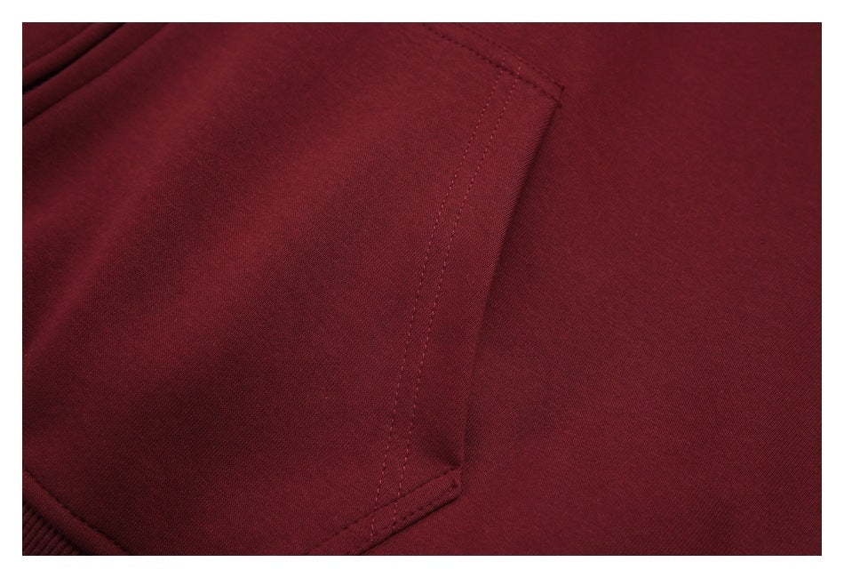 Close-up of the burgundy hoodie’s kangaroo pocket stitching and fabric.