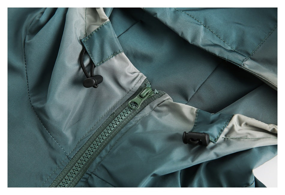 Close-up of a teal jacket hood showing the zipper, light gray lining, and adjustable drawcord toggles.