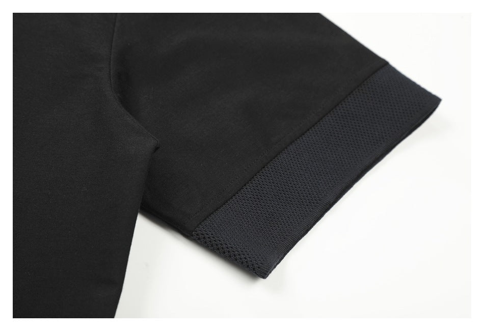 Close-up of a black garment sleeve with a wide textured knit cuff.