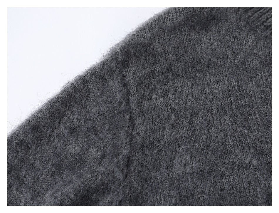Close-up of charcoal gray knit fabric with a diagonal seam or garment edge.