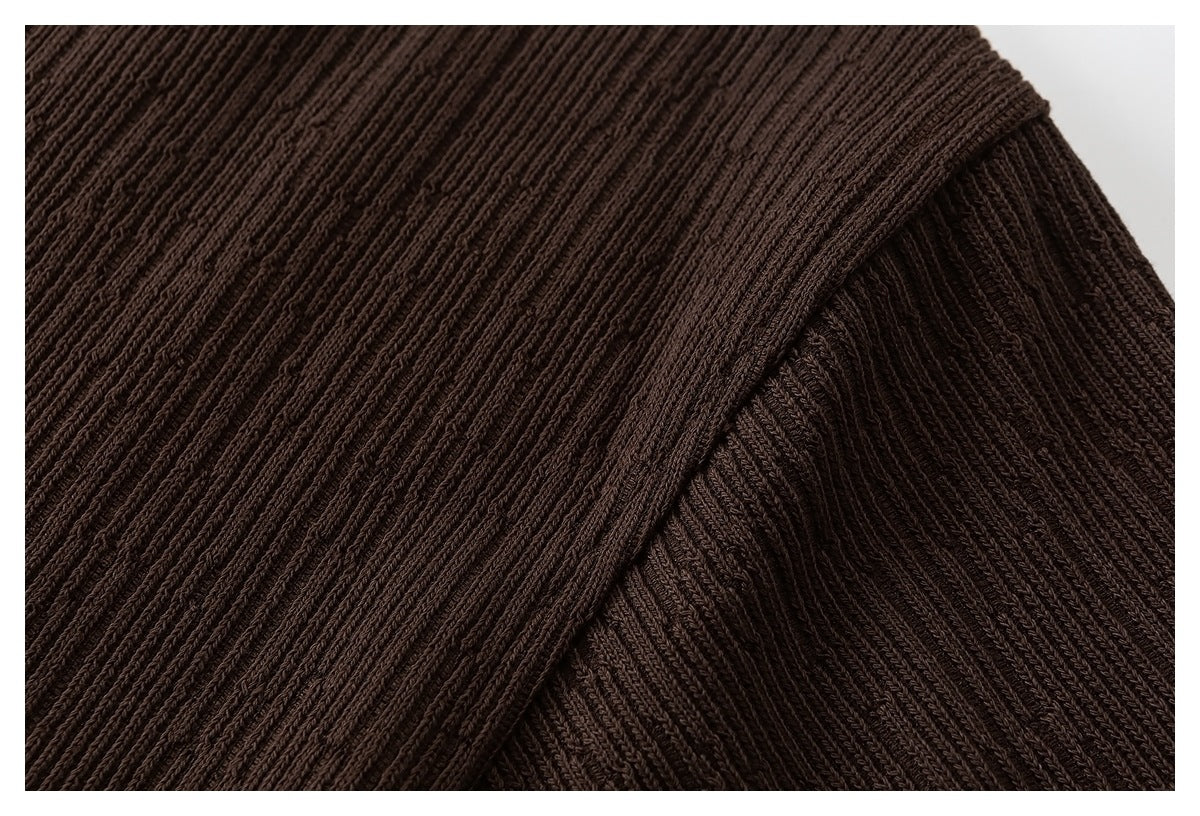 Close-up of dark brown ribbed knit fabric with a folded or overlapping edge.
