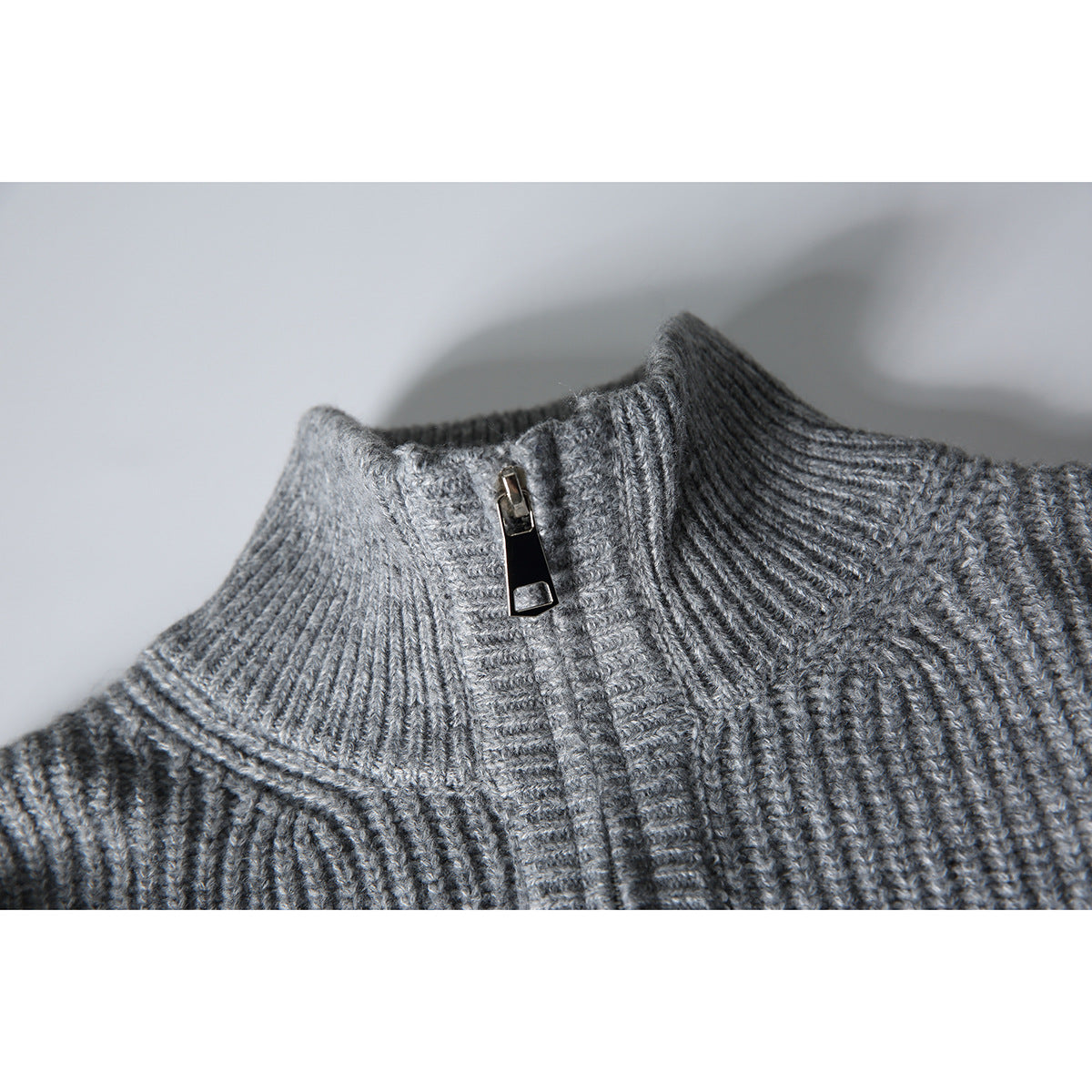 Close-up of a gray rib-knit stand collar with a front zipper.