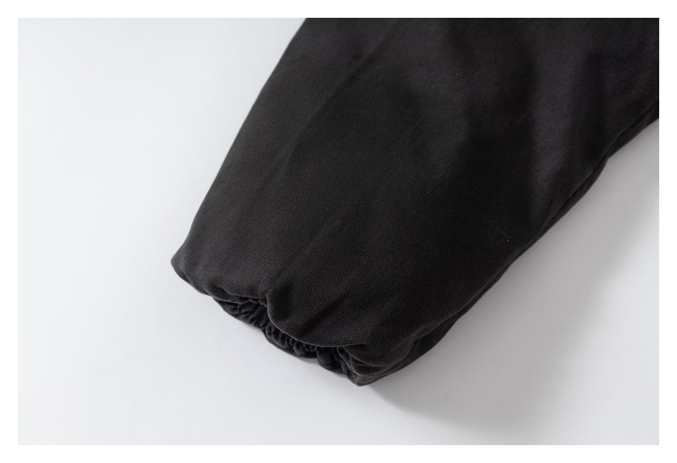 Close-up of a black jacket sleeve ending in an elasticized cuff.