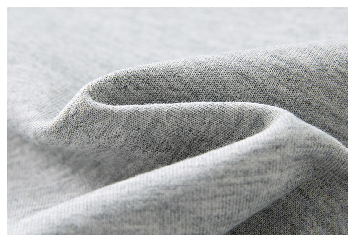 Close-up of light gray heathered knit fabric draped in soft folds.