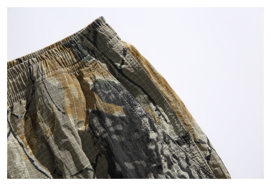 Close-up of a side pocket seam and elastic waistband on the camouflage shorts.