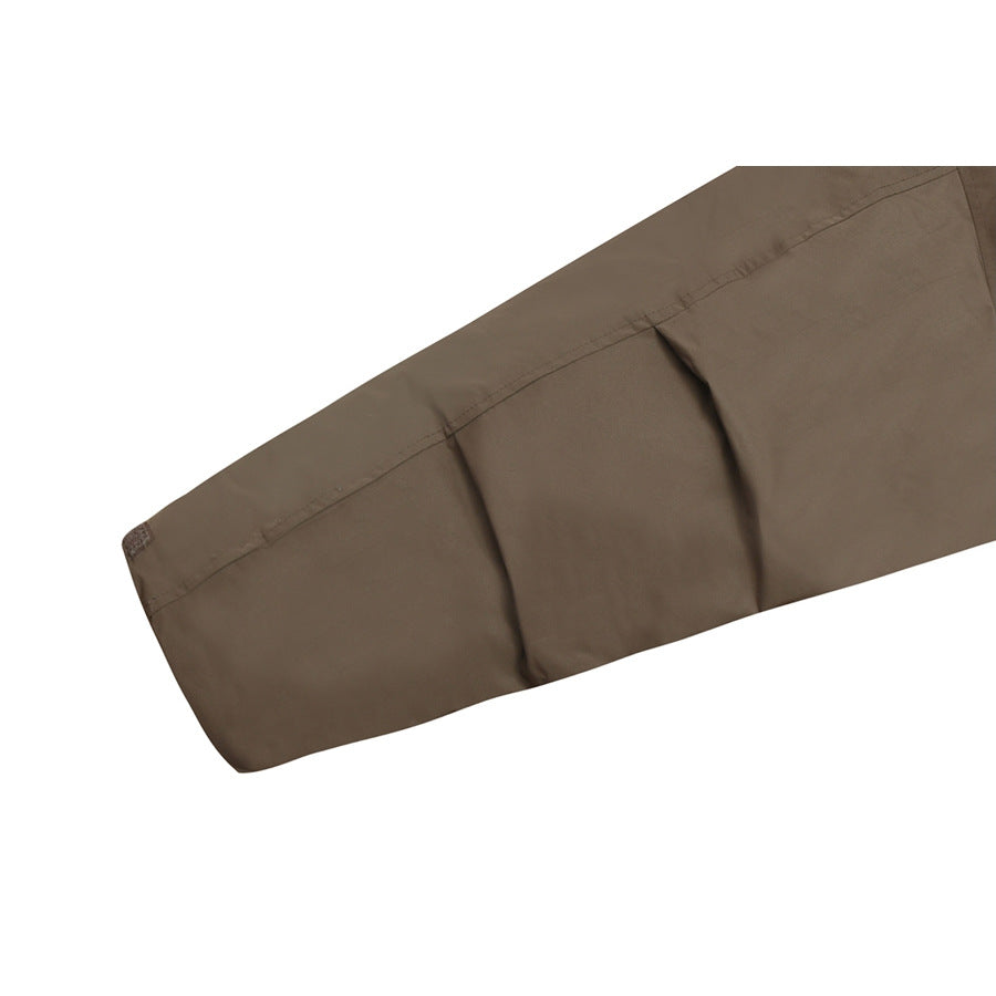 Close-up of a brown jacket sleeve showing stitched seams and gathered folds.