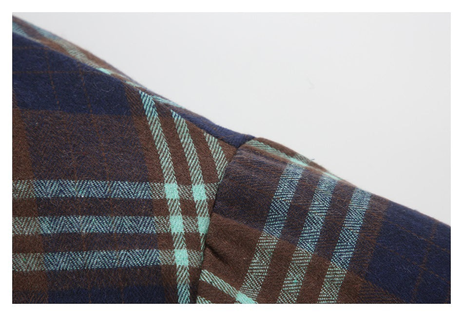 Close-up of the jacket's brown, navy, and aqua plaid fabric at a seam.