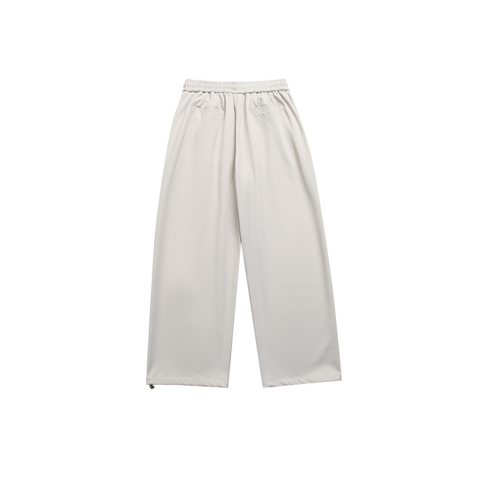 Back view of light beige wide-leg trousers with an elastic waist and two rear welt pockets.
