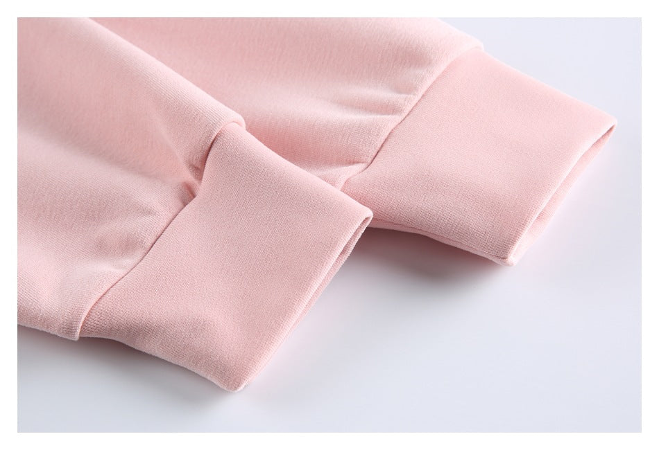 Close-up of two pale pink hoodie sleeves with wide ribbed cuffs.