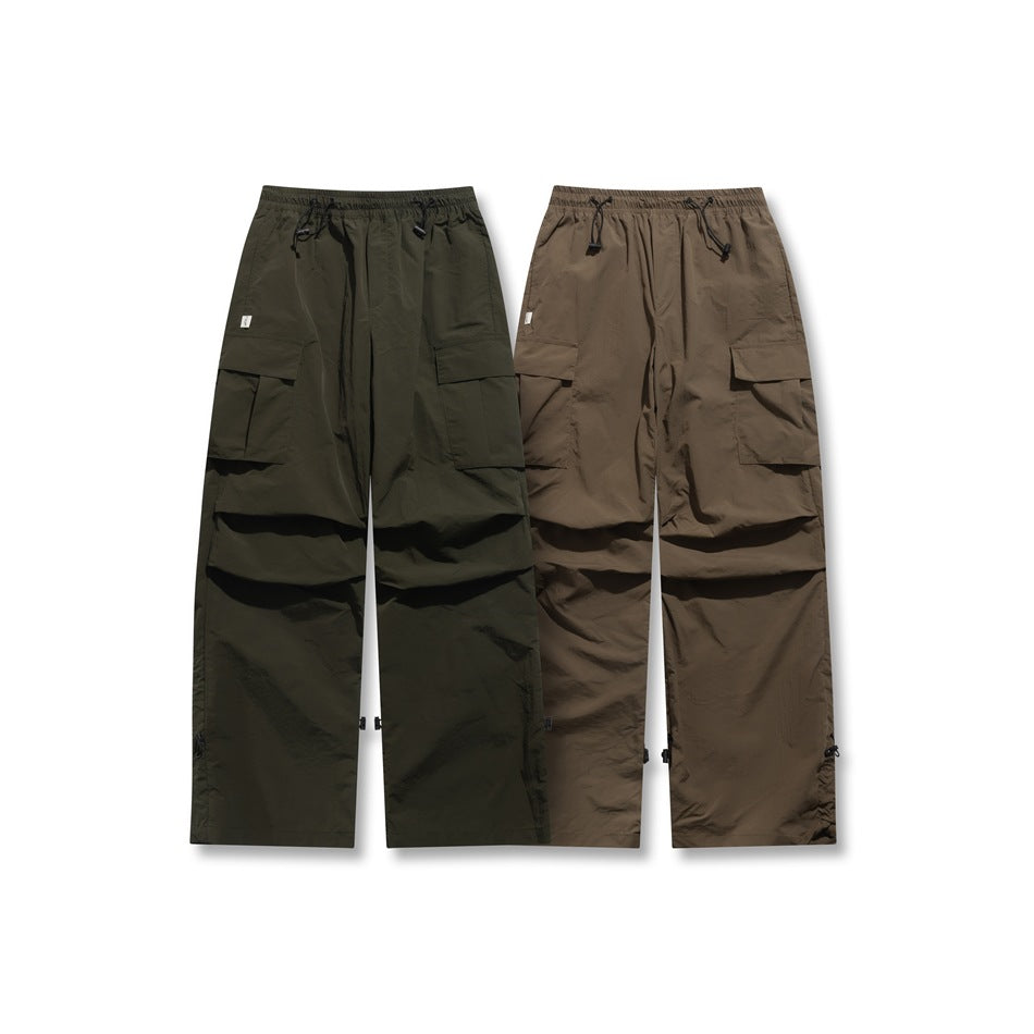 Front views of wide-leg cargo pants in dark olive and brown, with elastic drawcord waists and flap pockets.