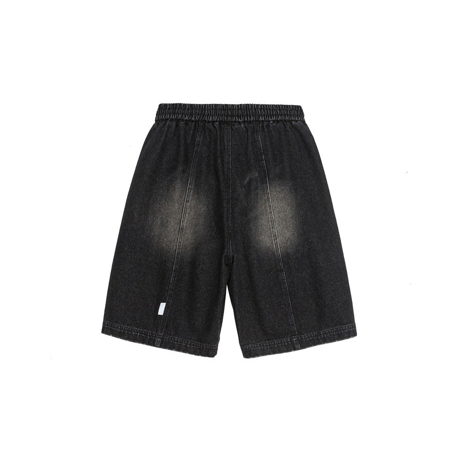 Back view of black washed denim shorts with elastic waistband, center seam and small white tag