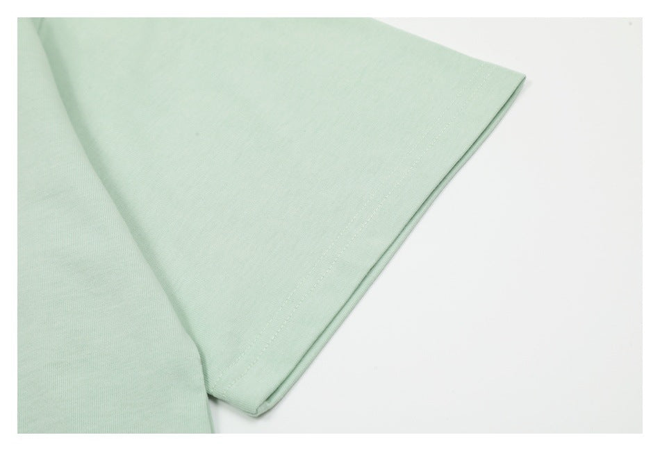 Close-up of a pale mint garment sleeve edge with neat double stitching.